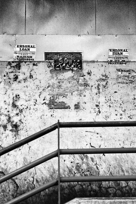 A wall filled with torn posters near Marine Lines