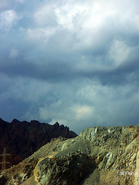 Quarried Mountains in foreground, other in shadow -- Fujairah