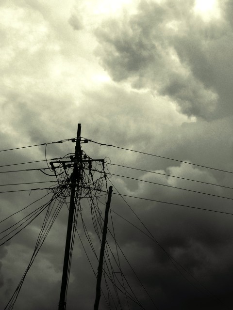 A tangled electric pole against rain clouds in Navi Mumbai in black and white A tangled electric pole against rain clouds in Navi Mumbai in black and white