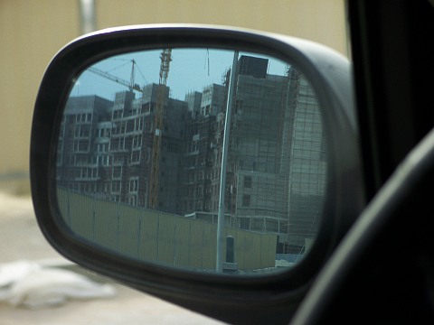 View of construction on the Palm Jumeirah crescent, in a rear view mirror