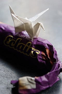 Photo of a papercraft origami swan placed on a roll of sweets