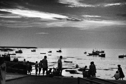 Fishing boats and people take in the sunset near Backbay bus depot