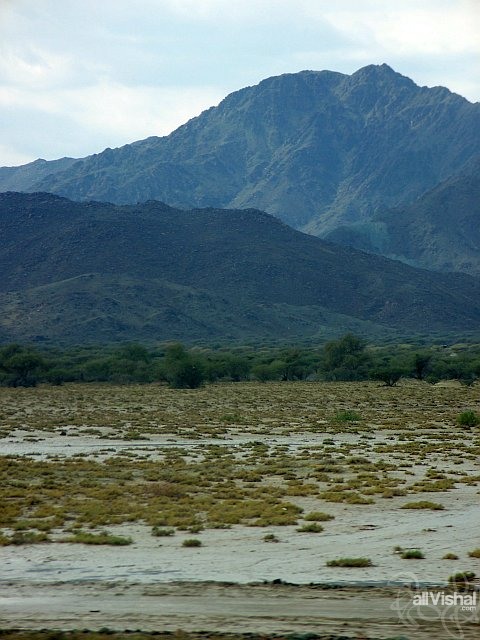 Dry salt marshland at the base of mountains in Fujairah