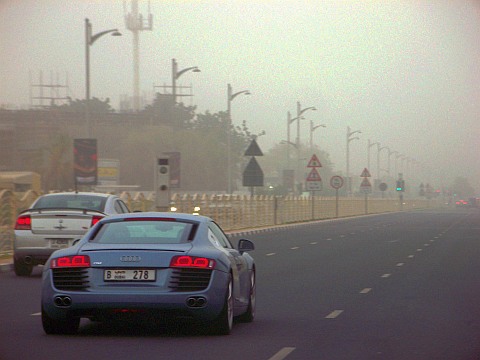 An Audi R8 supercar on the road in Dubai in a sandstorm