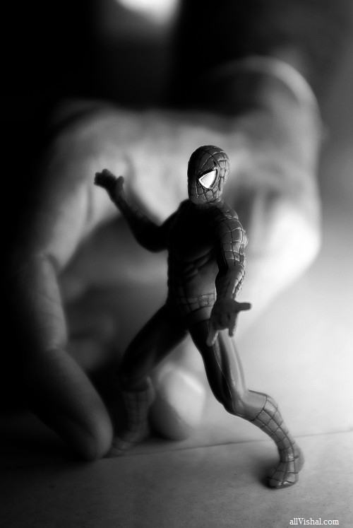 A hand holding a small spider-man figure